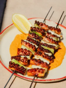 Grilled octopus skewers with romesco sauce