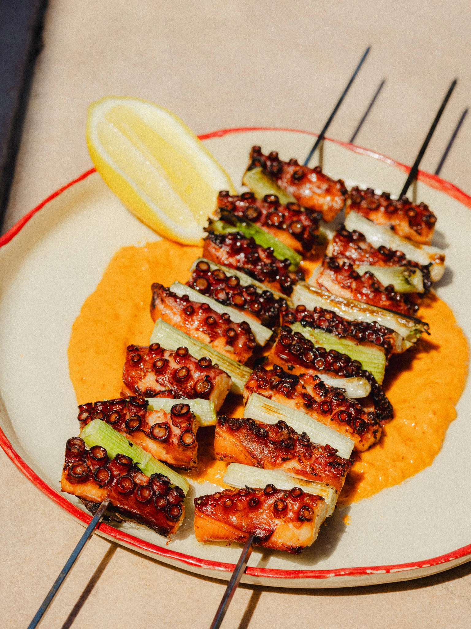 Grilled octopus skewers with romesco sauce